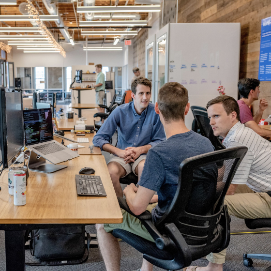 Three men are sitting in an office and discussing something